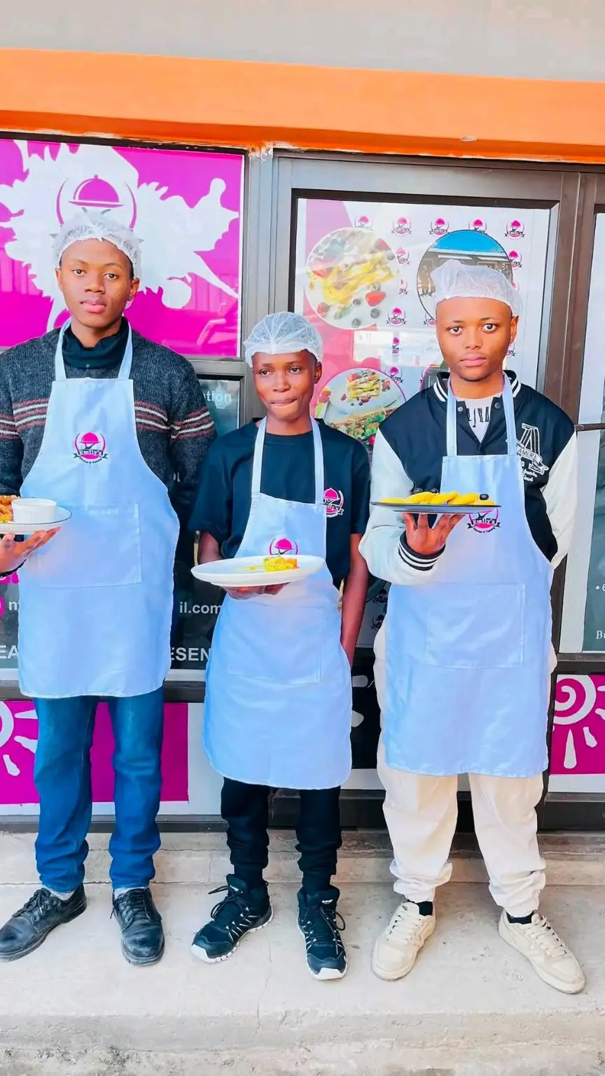 Three Emily's Kitchen trainees presenting their dishes